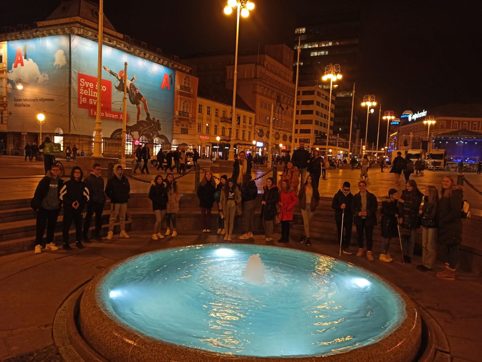 Na slici se nalazi 16 učenika i radnici Centra koji se slikaju poredani u polukrug pokraj poznatog zagrebačkog Manduševca.