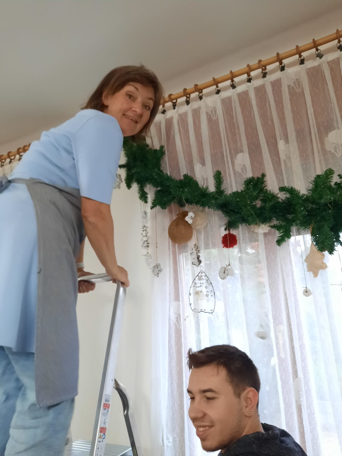 Profesorica Tanja postavlja girlandu, a pomaže joj Kristijan