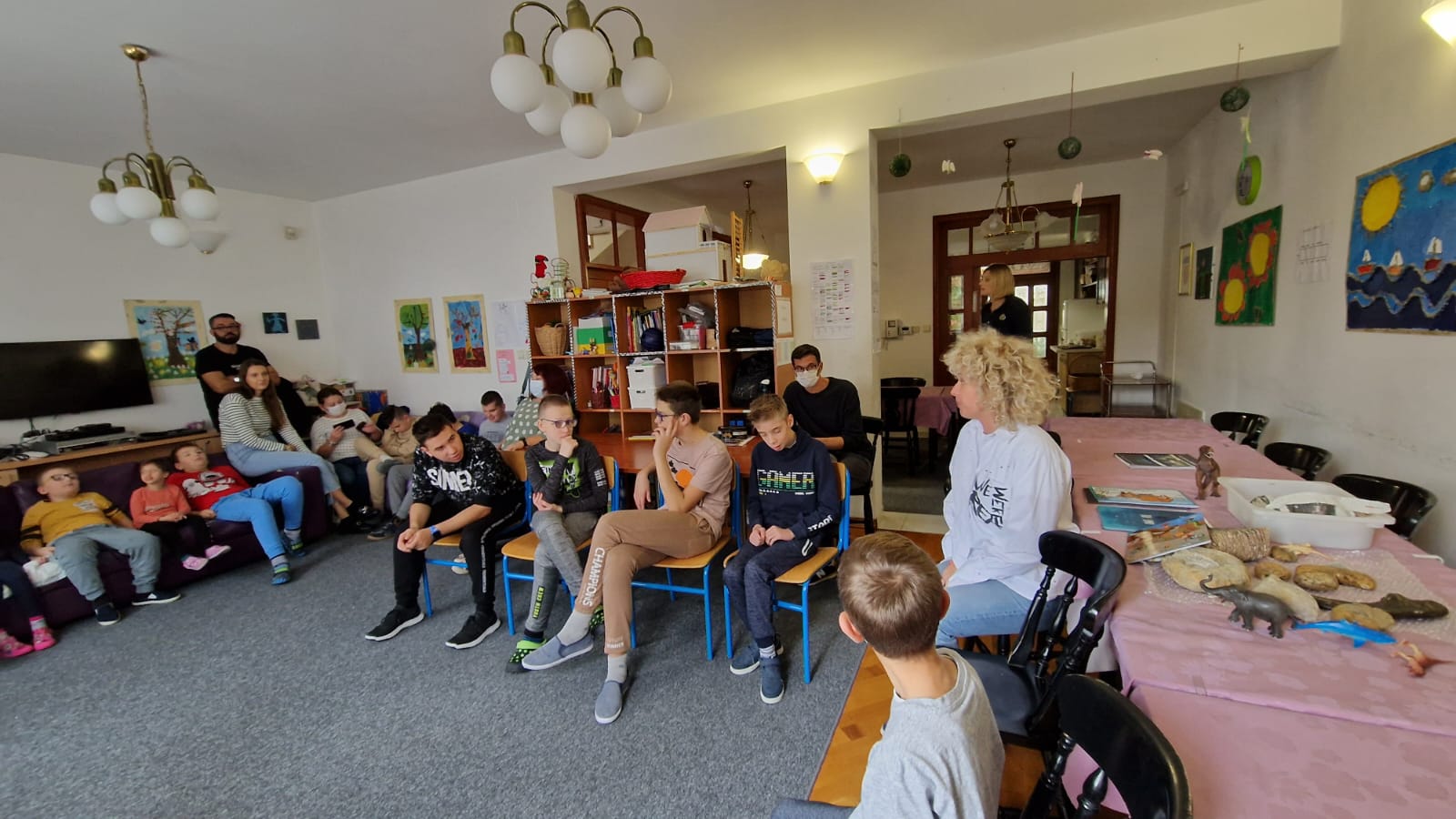 Učenici sjede u boravku i slušaju priču o fosilima